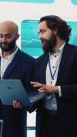 Vertical Team of investors analyzing profit amount and making decisions to fund another business project, examine big data on a huge display. Associates verifying efficiency and budget. Camera A. video