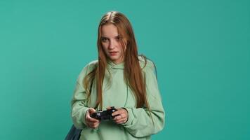 Young girl spamming controller buttons, disappointed after receiving game over screen. Woman upset after losing videogame, playing with gamepad, studio background, camera A video