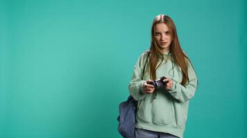 Euphoric woman playing intense gaming console game, celebrating win, studio background. Ecstatic young girl using controller, excited after being victorious in videogame, camera B video