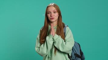 Woman doing begging hand gesture, in ardent need of favor from friend, isolated over studio background. Young girl doing please gesturing, requesting assistance, camera A video