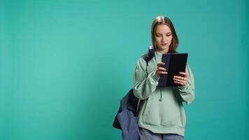 Woman scrolling on tablet touchscreen, checking social media feed, catching up with friends. Happy person relaxing by browsing internet websites, isolated over studio background, camera B video