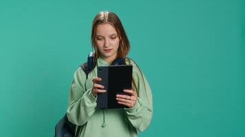 Woman scrolling on tablet touchscreen, checking social media feed, catching up with friends. Happy person relaxing by browsing internet websites, isolated over studio background, camera A video