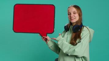 Smiling woman holding red speech bubble sign of empty copy space for message. Joyous teenager presenting thought bubble cardboard used as promotion concept, isolated over studio background, camera A video