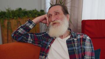 Happy calm senior man smiling dreaming resting, relaxing, good news, feel satisfied at home couch video