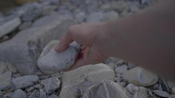 Selecting a rock from a rough landscape to focus on tactile experience and connection with nature video