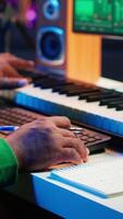 Vertical In his home studio, songwriter writes down lines and melodic elements to create new tunes. Using digital audio workstation software, composing and recording songs in post production. Camera A. video