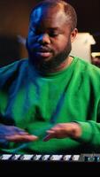 Vertical Famous piano teacher conducting internet master class via vlog tutorial, teaching people how to hit the right notes on electronic keyboard. Young artist performer hosts synthesizer lessons. Camera A. video