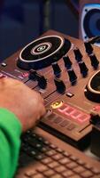 Vertical Music technician with headset mixing and mastering his audio recordings, operating on console in home studio. Musician producer creating new tunes with sound effects in post production. Camera A. video