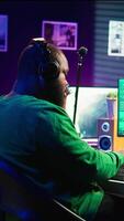 Vertical Audio technician works with recording tools in his home studio, using mixing console and pre amp knobs to add sound effects on tracks. Composer editing new tunes in post production. Camera B. video