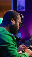 Vertical Skilled male composer producing new songs on his mixing console, operating on professional gear in home studio. Artist audio engineer twisting knobs to adjust sound levels on tracks. Camera B. video