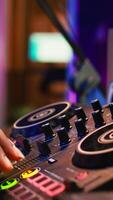 Vertical Audio engineer with headset mixing and mastering his recorded files, operating on a professional soundboard in home studio. Artist producer composing new tracks with sound effects. Camera B. video