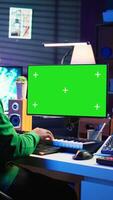 Vertical Songwriter operates on synthesizer piano keys next to isolated display, composing new music with instruments and stereo tools in home studio. Artist producer works with green screen. Camera B. video