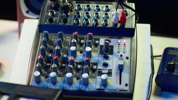 Empty home studio desk with motorized faders and pre amp knobs used with a mixing console and equalizer to produce music. Modern space with amplifier and devices for mix and master. video
