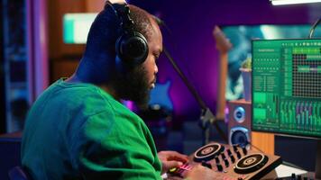 Skilled music producer composing new soundtracks on console and daw software, working with stereo gear in home studio. Young artist engineer uses pre amp knobs, signal processing. Camera A. video