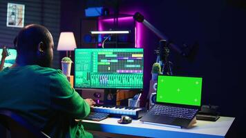 Composer mixing and mastering tracks on professional software, isolated mockup screen. Technician adding sound effects and adjusting volume levels with console, producing new music. Camera B. video