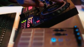Audio engineer producing new music on mixing console in home studio, working with sound effects and pre amp knobs. Skilled producer creating songs and adjusting volume levels. Close up. Camera A. video