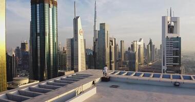 A young man walks on the roof of a skyscraper with a helipad video