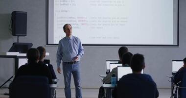 meia idade masculino professor Falando dentro sala de aula, alunos com laptops estudando dentro baseado em computador classe video
