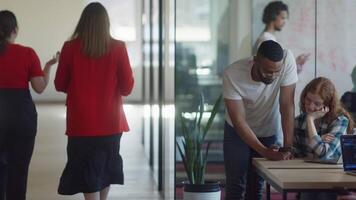 A diverse group of colleagues collaborates using laptops, mobiles, and tablets to tackle business challenges and enhance productivity through teamwork and innovative technology. video