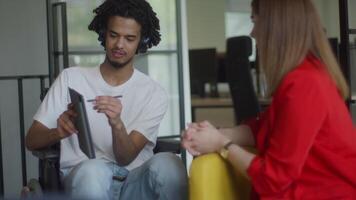 African American businessman in a wheelchair engages in a professional discussion with his colleague, addressing various business challenges and exploring solutions in an inclusive and diverse modern video