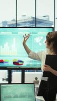 Vertical Corporate associates looking into project details and timetables in conference room, establishing budget and operations to accomplish objectives in a competitive business environment. Camera B. video
