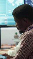 Vertical Diverse work team collaborating on project management tasks, utilizing smart technology and detailed analytics to optimize resource allocation and ensure enterprise objectives. Camera A. video