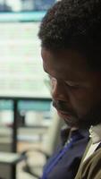 Vertical Important business investor studying development progress reports on tablet, examining big data visualization tools during a briefing meeting with executive board members. Management. Camera B. video