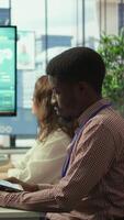 Vertical Diverse work team collaborating on project management tasks, utilizing smart technology and detailed analytics to optimize resource allocation and ensure enterprise objectives. Camera B. video
