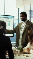 Vertical Diverse marketing team presenting a detailed reports analysis of recent campaigns, utilizing infographics and digital marketing insights to optimize future strategies and improve ROI. Camera B. video
