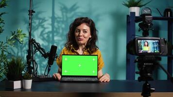 Media star reviews newly launched chroma key gaming laptop, comparing features with older models. Internet show host filming for social media, analyzing green screen notebook video