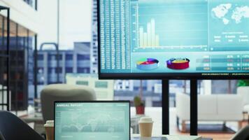 Sleek corporate office with a computer displaying detailed infographics, perfect for executive business meetings or financial planning and project development in a multinational company. video