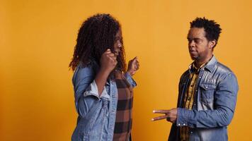 Cheerful positive married couple playing rock paper scissors in studio, having fun with a children activity and competition. Playful joyful man and woman trying to make a decision. Camera B. video