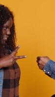 Vertical Cheerful positive married couple playing rock paper scissors in studio, having fun with a children activity and competition. Playful joyful man and woman trying to make a decision. Camera A. video