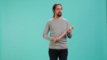 Portrait of menacing man threating to hit enemy during fight. Wrathful Arab person full of rage intimidating mate, holding weapon, isolated over studio background, camera A video