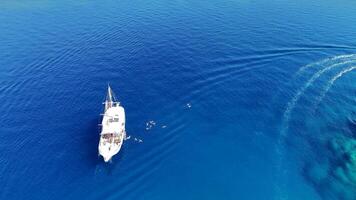 Drone View of Yacht Moored by Island with Tourists Swimming in Clear Waters video