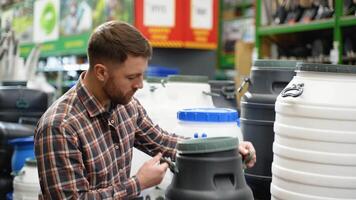 A man in a hardware store chooses a new water barrel video