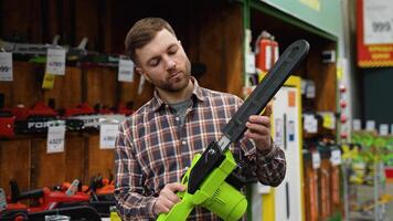 A man is buying new chainsaw in a tool store video