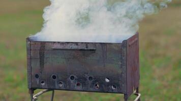 Smoke Comes Out of the Metal Brazier. Grill Cooking Outdoors and Preparing for Barbecue Kebab Grilling. Kindling Coals in the Mangal. Dynamic Shot video