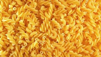 Uncooked Fusilli and Chifferi Rigati Pasta - Top View. Fat and Unhealthy Food. Classic Dry Macaroni, Slowly Rotating Background. Raw Different Macaroni Pasta Texture - Rotate Left video