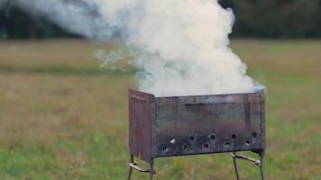 Smoke Comes Out of the Metal Brazier. Grill Cooking Outdoors and Preparing for Barbecue Kebab Grilling. Kindling Coals in the Mangal. Dynamic Shot video