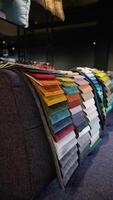Fabric and textiles samples in a factory shop or store. Different colors and patterns on the market. Vertical video