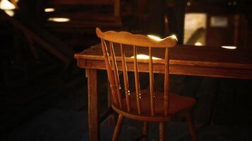 Sunlight streaming through the window onto a wooden table and chair in an attic video