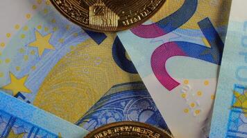 Bitcoin Coins on the 20 Euro Banknotes - Top View, Macro. Euro Money Cash and Cryptocurrency. A Lot of Twenty Euro Bills. Finances, Blockchain and Electronic Money Concept - Slow Rotation Left video