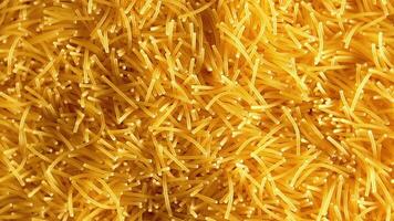 Background of Uncooked Noodles that Slowly Rotating Clockwise - Top View, Close-Up. Texture of Dry Vermicelli Turning Around. Raw Pasta with Low Key Light - Right Rotation video