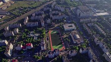 Buildings with street in small town with empty football soccer field video