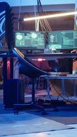 Vertical High tech computer system running malicious code in empty basement, handheld camera shot. PC monitors in empty neon lit criminal hideout used by hackers to commit illegal activities, camera A video