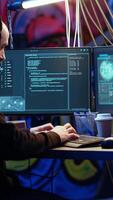 Vertical Hooded hacker in graffiti painted hideaway targeting vulnerable unpatched connections, having burst of joy after getting access granted past security and stealing valuable sensitive data video
