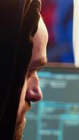 vertical malicioso homem hackear, roubando crédito cartão números e manipulando bancário sistemas para dele próprio pessoal ganho. extremo fechar acima do Vampiro programador corrida código dentro grafite pintado porão, Câmera b video
