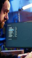 Vertical Hacker in hidden shelter excited after managing to launch successful DDoS attack on website, celebrating, crashing it by sending large amounts of traffic from multiple sources, camera A close up video