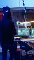Vertical Hacker arriving with tablet in hidden base, deploying viruses on unaware victims computers, stealing sensitive and private information, selling it on darknet black market to highest bidder, camera A video